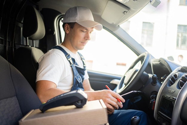 A male courier in the form of a driver delivering an order to a\
courier company at home