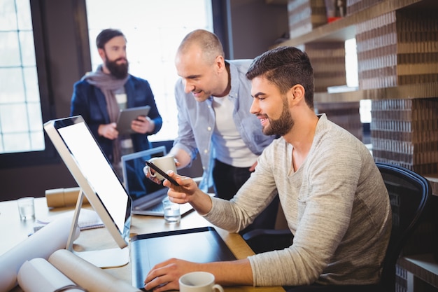 Colleghe creativi maschii che discutono sopra il computer