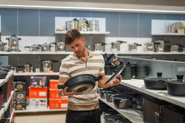Male customer choosing cooking pan