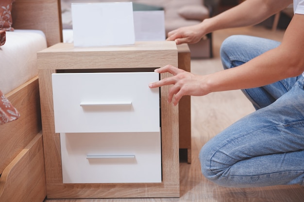 Male customer examining bedside nightstand table at furniture store