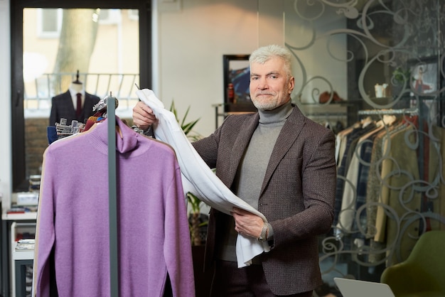 A male customer with a beard wears a suit in a boutique.