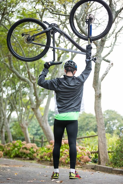 マウンテンバイクを運ぶ男性サイクリスト