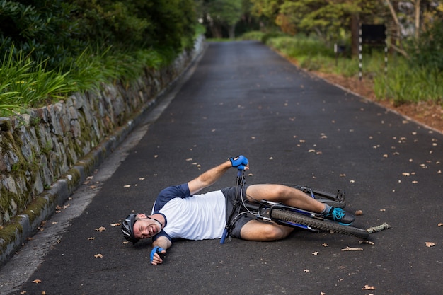Foto ciclista maschio caduto dalla sua mountain bike