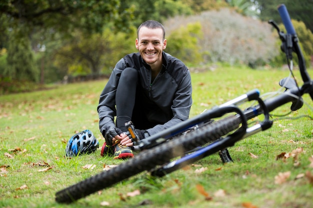 Male cyclist relaxing in park with mountain bike