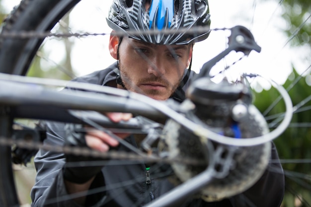 彼のマウンテンバイクを修復する男性サイクリスト