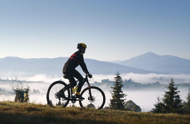 Male cyclist riding bicycle in mountains