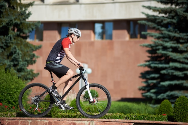 Male cyclist training on street edging