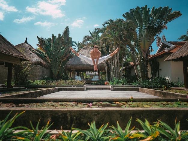 Ballerino maschio sulla spiaggia con le palme