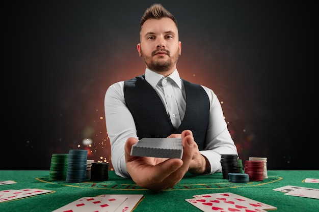 テーブルのカジノの男性ディーラー。カジノのコンセプト、ギャンブル、ポーカー、グリーンカジノテーブルのチップ。