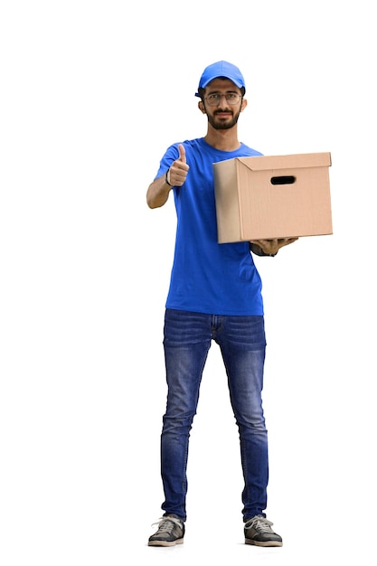 A male deliveryman on a white background in full height with a box shows a thumbs up