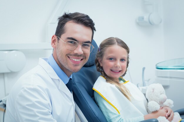 Male dentist examining girls teeth