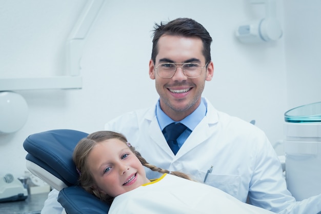 Male dentist examining girls teeth