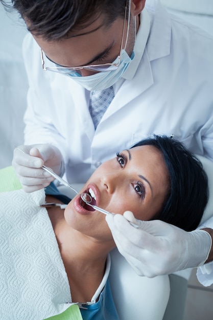 Male dentist examining womans teeth