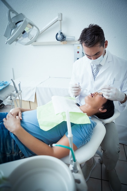 Мужской стоматолог осматривает зубы женщин