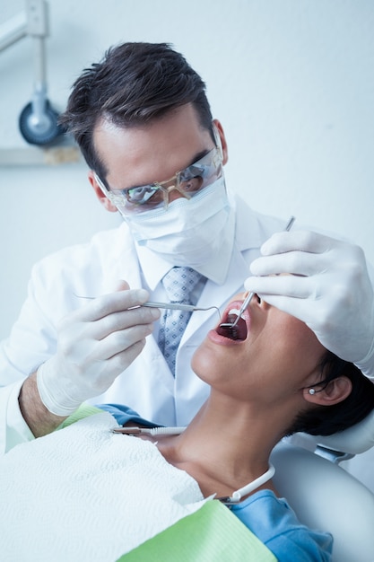 여 대 치아를 검사하는 남성 치과 의사