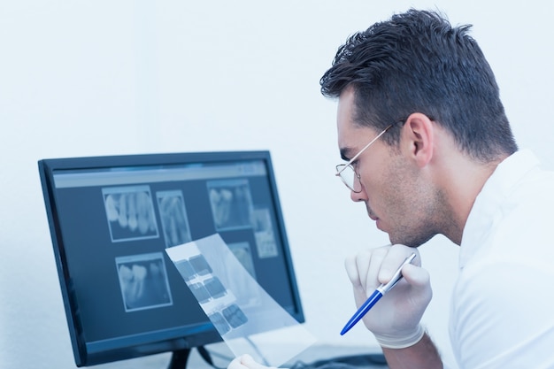 Male dentist looking at x-ray