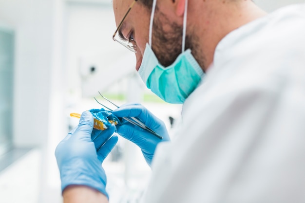 Male dentist preparing dental impression