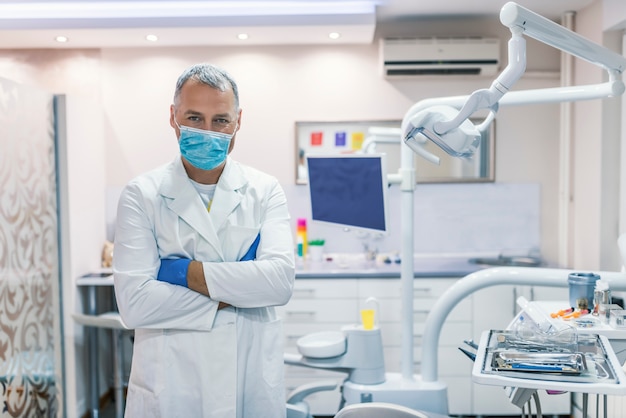 Male dentist standing with his hands crossed 