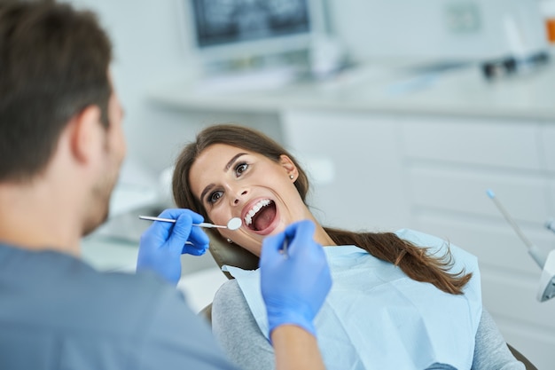 Male dentist and woman in dentist office