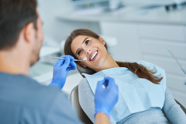 Male dentist and woman in dentist office