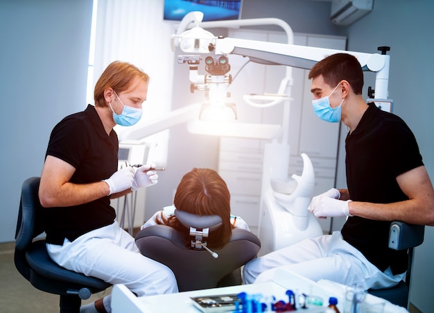 Male dentists and a patient in dentistry office