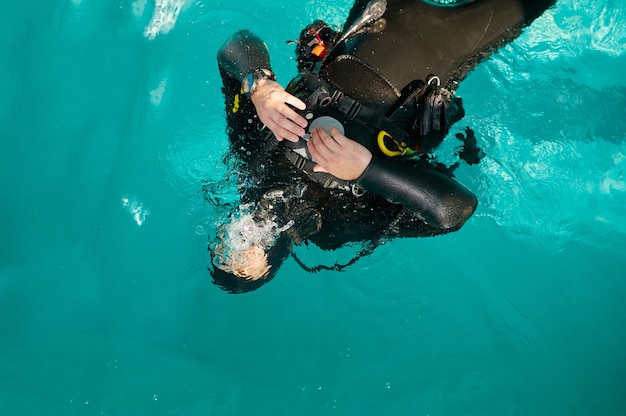 Фото Мужчина-дайвер в акваланге позирует в бассейне, вид сверху