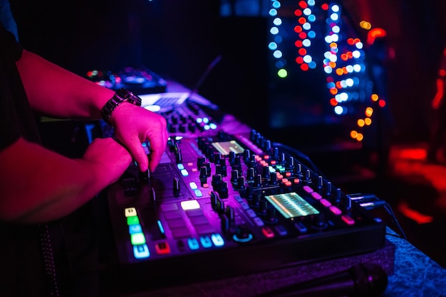 Male DJ mixes electronic music on a professional music controller