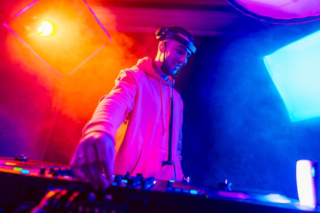 Male dj playing music in the night club