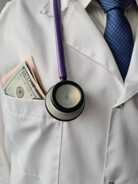 Male doctor chest with pile of hundred dollar bills in pocket closeup