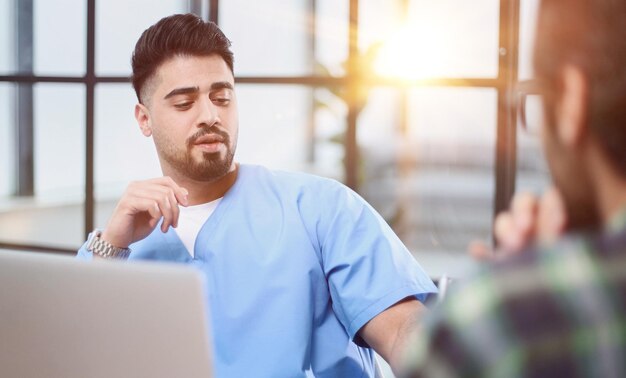 male doctor consulting patient filling form at consultation