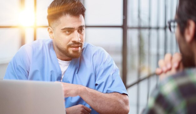 male doctor consulting patient filling form at consultation