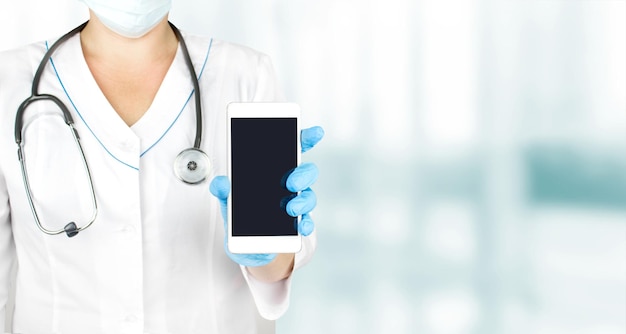 Male doctor demonstrating smartphone with blank screen for advertisement. Mock up. Copy space for your text,