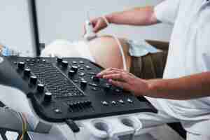 Photo male doctor does ultrasound for a pregnant woman in the hospital