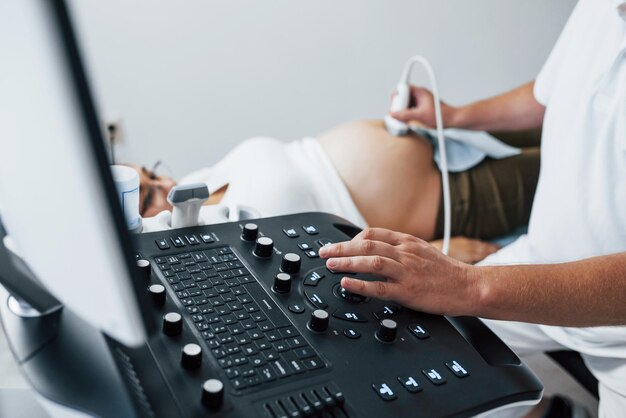 Photo male doctor does ultrasound for a pregnant woman in the hospital
