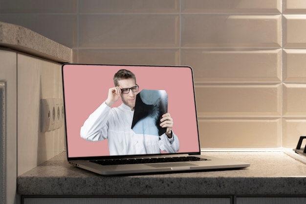 A male doctor doing examination on laptop webcam call online to the patient at home