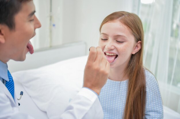 Male doctor examining girl in hospital ward