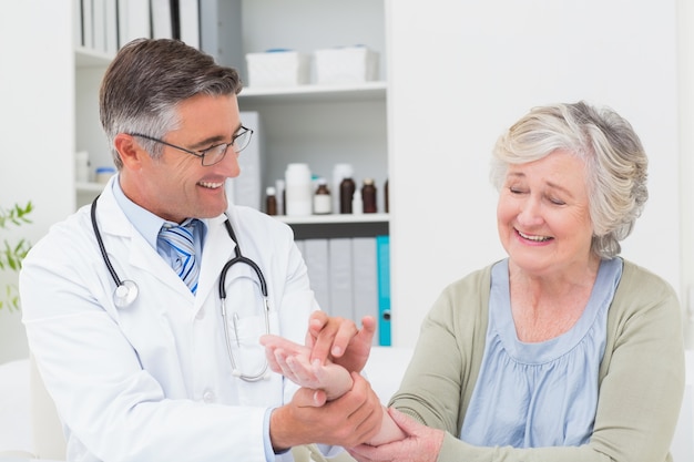 Foto mano d'esame dei pazienti di medico maschio alla tavola