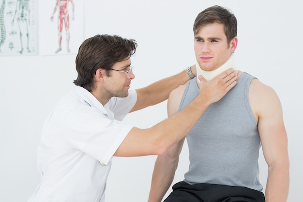 Male doctor examining a patients neck