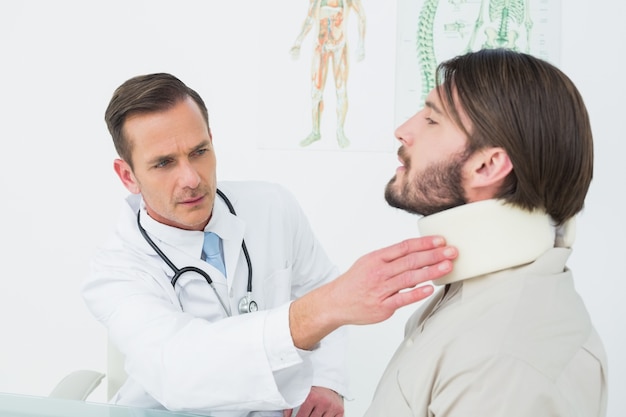 Male doctor examining a patients neck