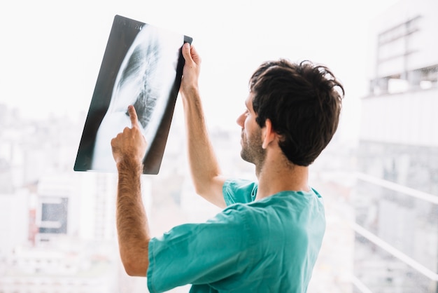 Photo male doctor examining x-ray