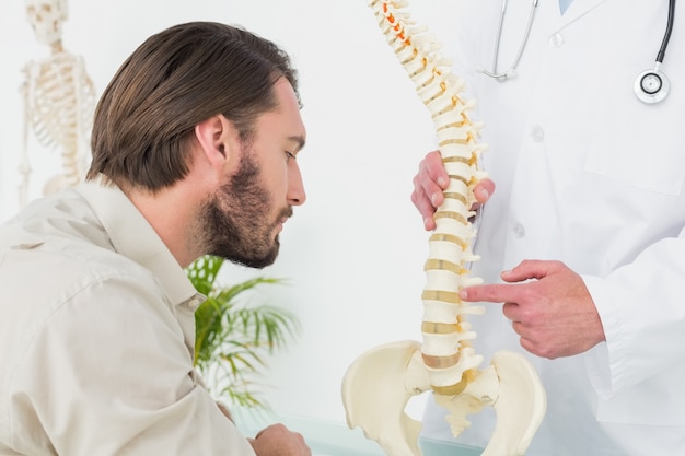 Photo male doctor explaining the spine to a patient