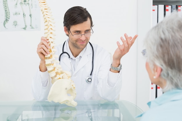 Male doctor explaining the spine to a senior patient