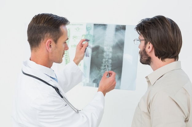 Male doctor explaining spine xray to patient