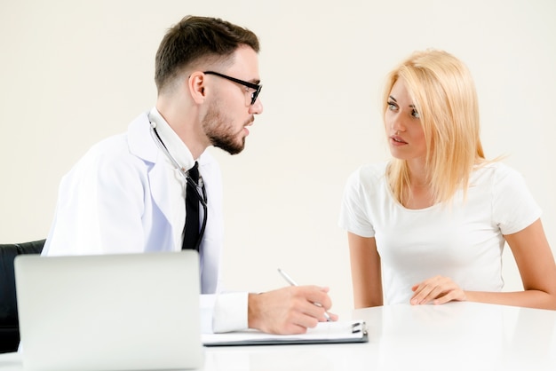 Male Doctor and Female Patient in Hospital Office