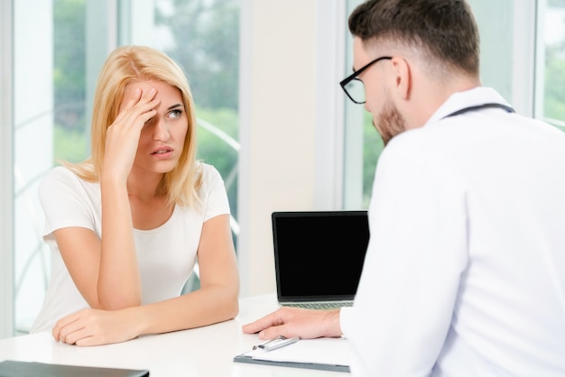 Male Doctor and Female Patient in Hospital Office