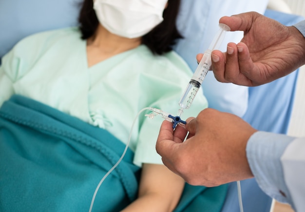 Photo male doctor gives pain medication through saline solution