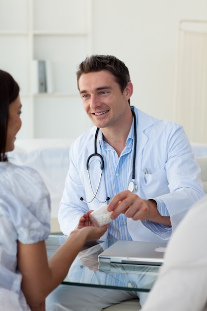 Photo male doctor giving pills to a female patient