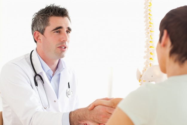 Male Doctor greeting a female patient