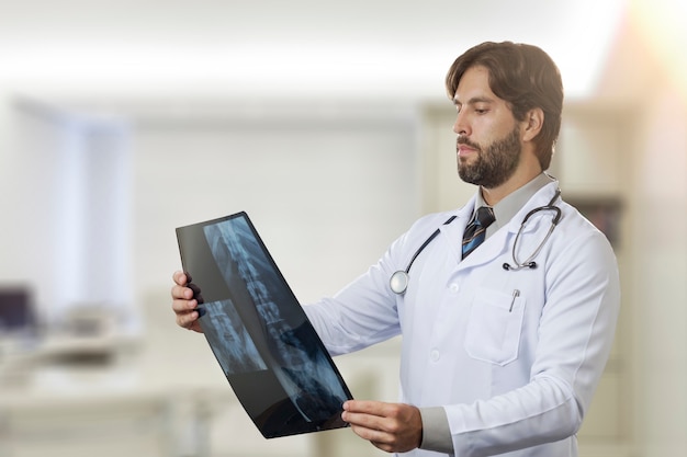 Photo male doctor in his office looking at a x-ray