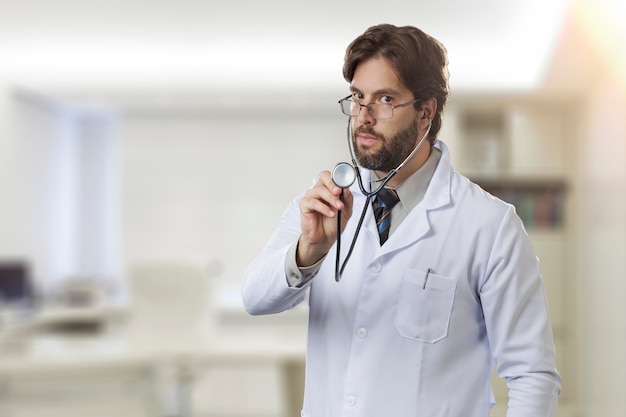 Male doctor in his office using a stethoscope